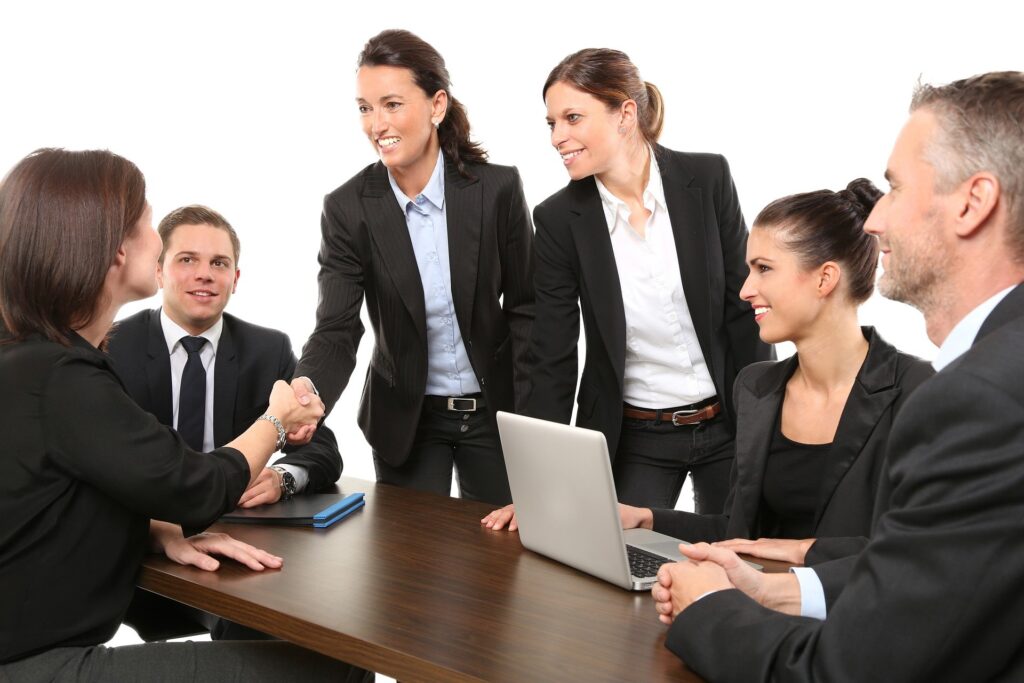 woman shaking hands with a team of people