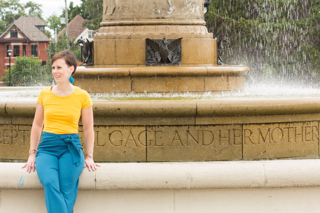 woman leaning on water fountain