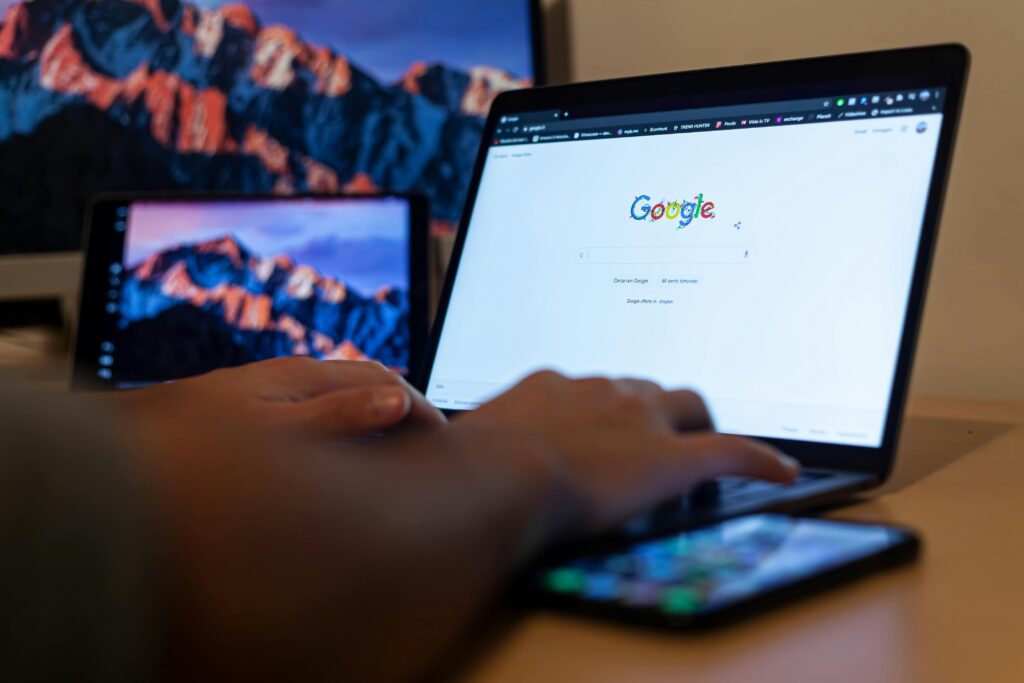 hands on a laptop that has Google displayed