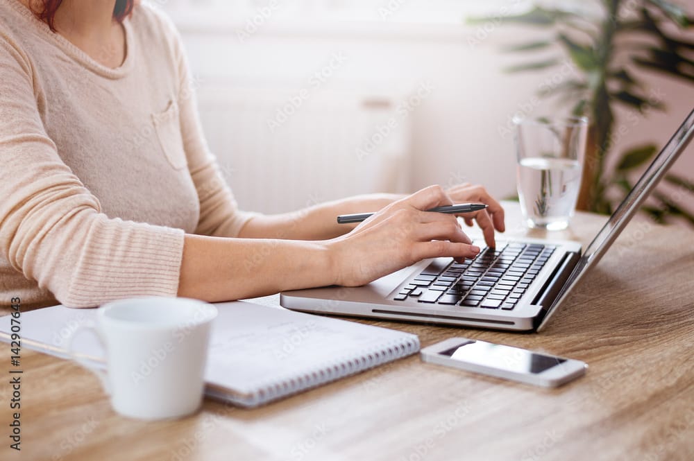 Female hands typing on the laptop keyboard
