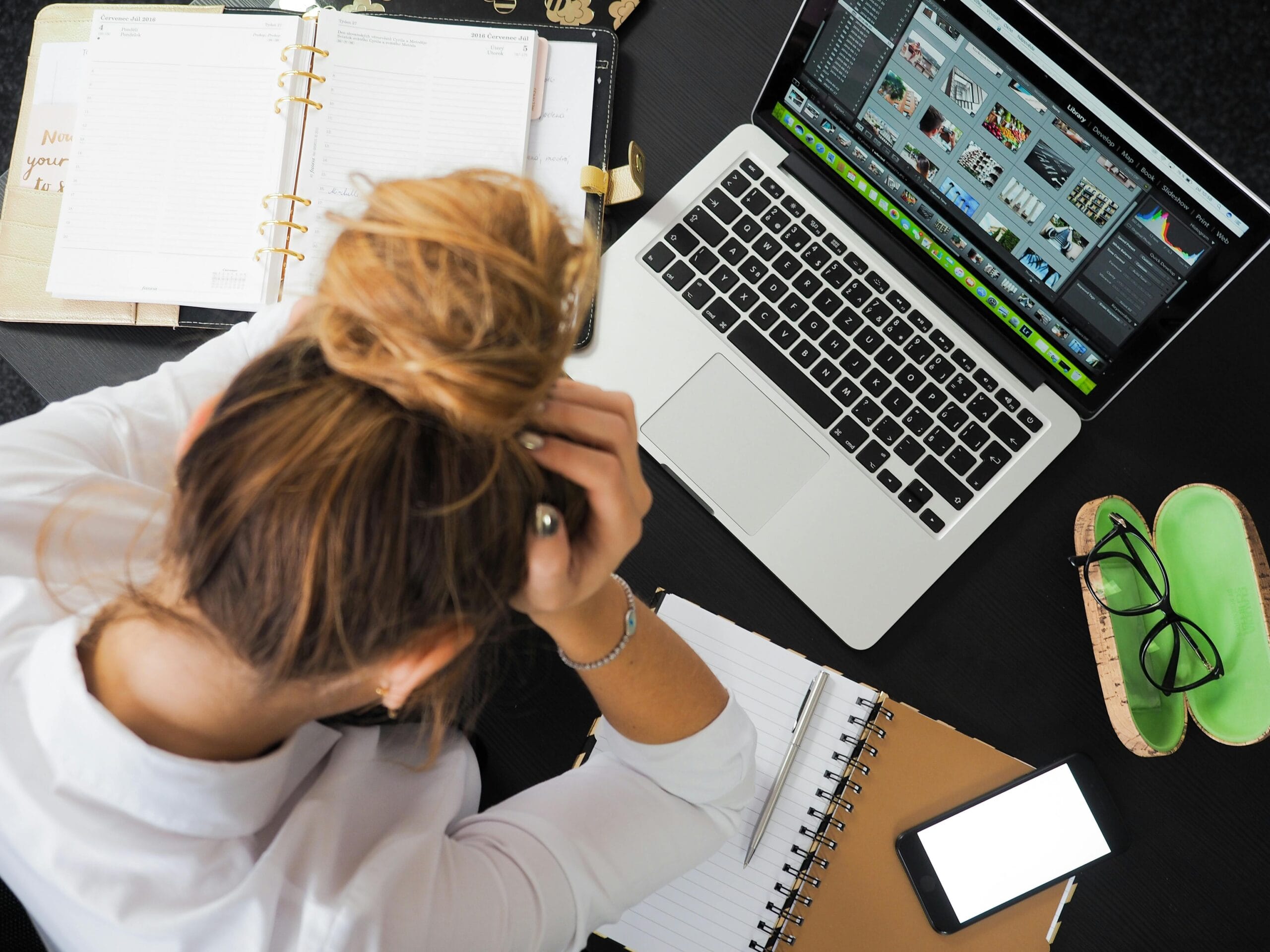 woman at desk with hands in her hand, looking frustrated
