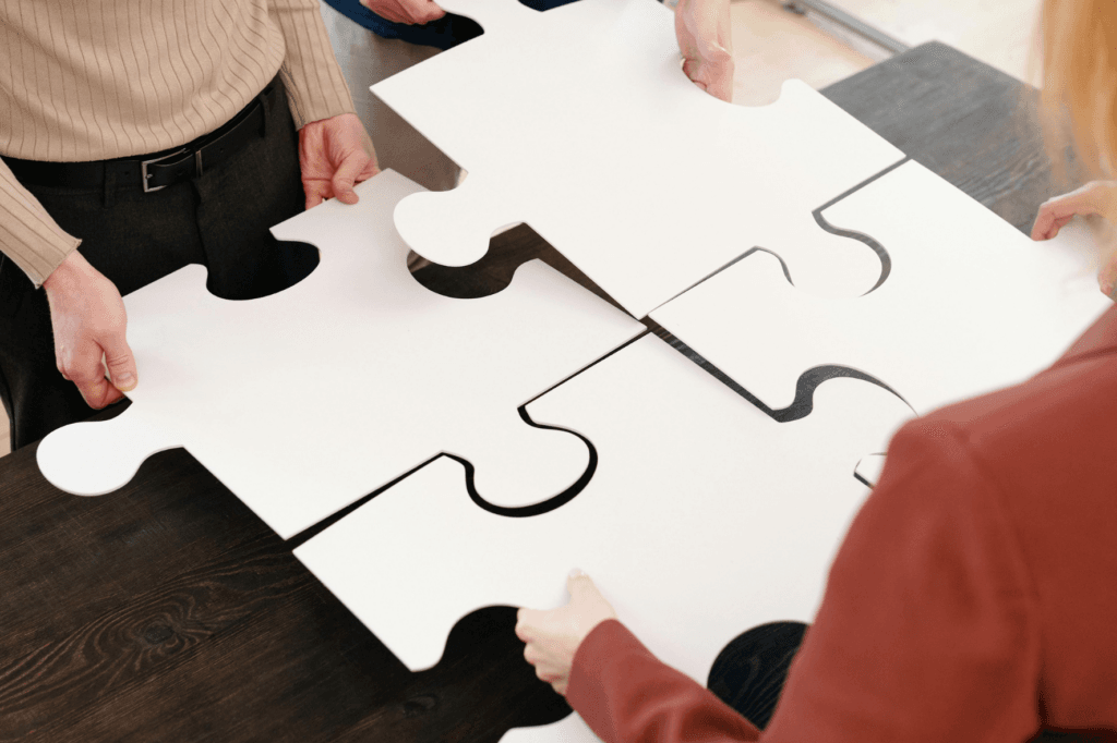 4 giant puzzle pieces being held by people's hands